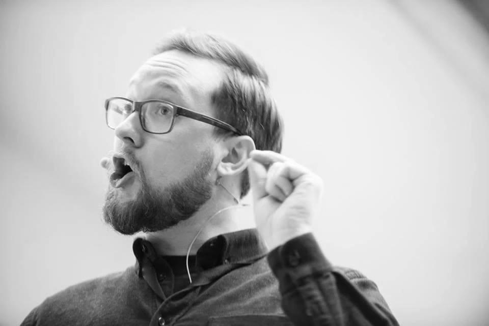Dan Hesketh speaking, with a microphone at his ear.